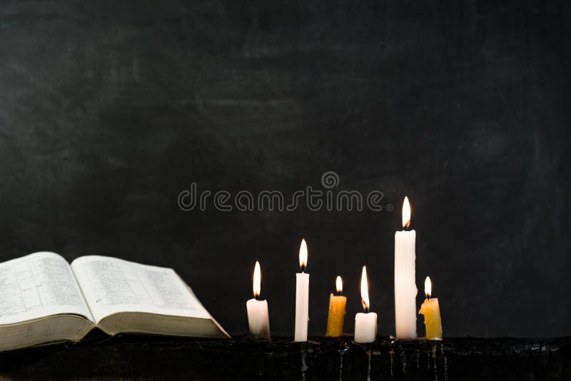 Candles on an old wooden burnt table. Beautiful dark background. Religious concept. stock images Candles on an old wooden burnt table. Beautiful dark background. Religious concept. stock images
