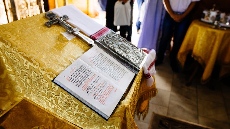 Bible on reading-desk, sacred lectern in the church decorated with golden friezes and ornaments, open book - gospel in Old Russian