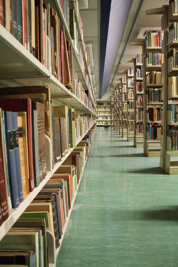 A quiet section of a university library with steel shelves full of various books. A quiet section of a university library with steel shelves full of various books.