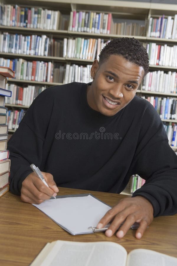 Bibliothèque de Studying In College d'étudiant masculin photographie stock Bibliothèque de Studying In College d'étudiant masculin photographie stock