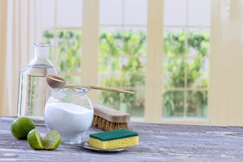 Eco-friendly natural cleaners baking soda, lemon and cloth on wooden table windows background,. Eco-friendly natural cleaners baking soda, lemon and cloth on wooden table windows background,