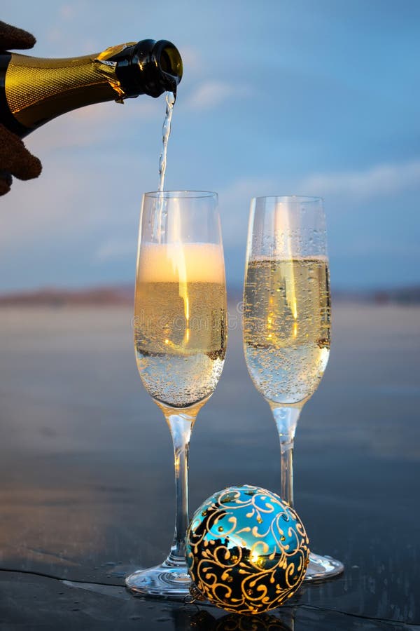 Bicchieri Di Champagne E Palloncini Di Natale Blu. Il Vino Spumante Viene  Versato Da Una Bottiglia in Un Bicchiere. Immagine Stock - Immagine di  congratulazioni, lifestyles: 204780203