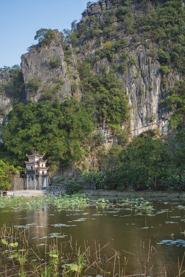 Premium Photo  Lone tourist with traditional vietnamese hat at bich dong  pagoda entrance gate, ninh binh vietnam, buddhist temple set amid jungle  and karst mountain range. traveling alone, keep social distancing.