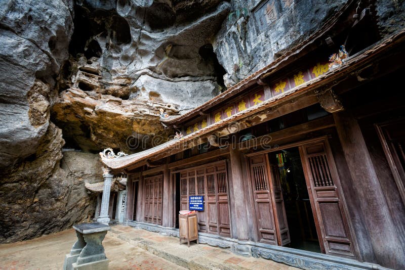 Premium Photo  Lone tourist with traditional vietnamese hat at bich dong  pagoda entrance gate, ninh binh vietnam, buddhist temple set amid jungle  and karst mountain range. traveling alone, keep social distancing.