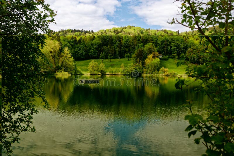 Bichelsee wiosną w południe sfotografowany z brzegu, patrząc na pustą platformę pływacką nad jeziorem, przed pięknym fotografia royalty free