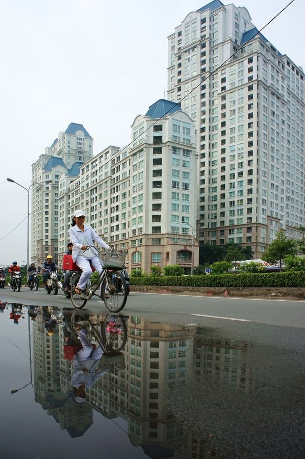 Bicicleta del paseo de la gente con el fondo del edificio alto imagen de archivo Bicicleta del paseo de la gente con el fondo del edificio alto imagen de archivo