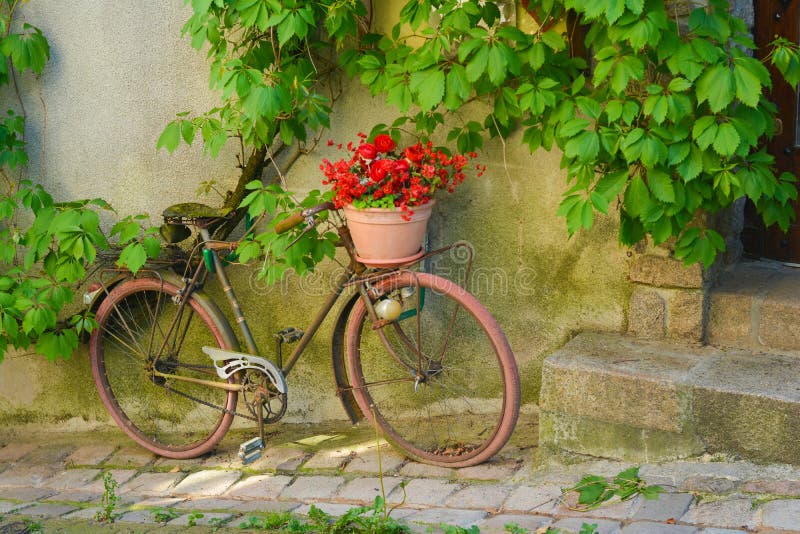 Bicicleta oxidada vieja con las flores en una cesta fotos de archivo libres de regalías Bicicleta oxidada vieja con las flores en una cesta fotos de archivo libres de regalías