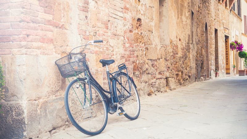 A bicicleta preta do vintage saiu em uma rua em Toscânia, Itália fotografia de stock royalty free A bicicleta preta do vintage saiu em uma rua em Toscânia, Itália fotografia de stock royalty free