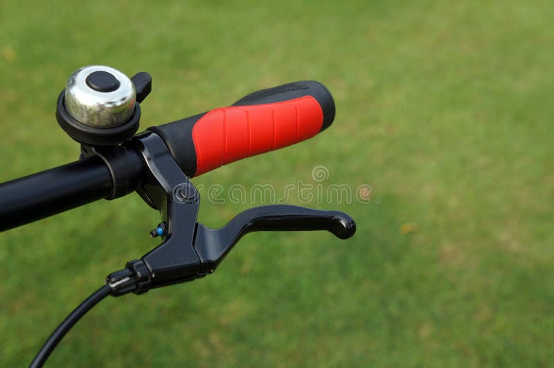 Bicycle Hand Brake and Bell on Green Grass Background Stock Image
