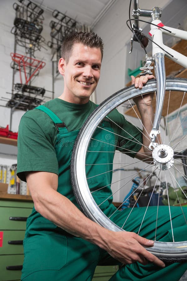 Bicycle mechanic repairing wheel on bike in a workshop royalty free stock images Bicycle mechanic repairing wheel on bike in a workshop royalty free stock images