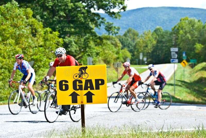 A group of cyclists taking part in a 100 mile ride making a turn for home behind a sign marking the route. This was the Six Gap Century and Three Gap Fifty bicycle ride sponsored by Dahlonega Wheel Works in and around Daholnega, Georgia on September 27, 2009. A group of cyclists taking part in a 100 mile ride making a turn for home behind a sign marking the route. This was the Six Gap Century and Three Gap Fifty bicycle ride sponsored by Dahlonega Wheel Works in and around Daholnega, Georgia on September 27, 2009.