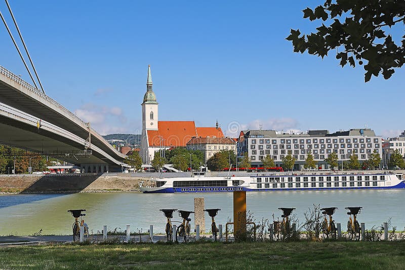 Požičovňa bicyklov v popredí, most a katedrála sv. Martina v pozadí, rieka Dunaj, Bratislava