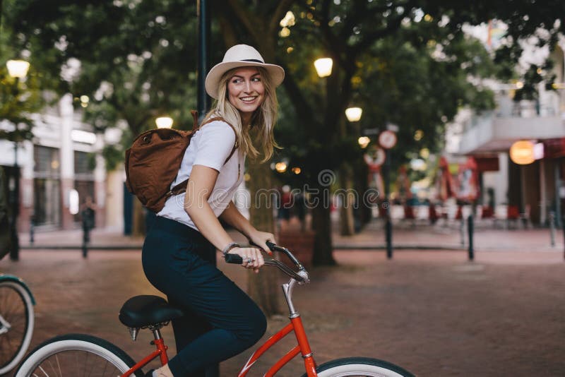 Bicyclette d'équitation de femme dans la ville image libre de droits Bicyclette d'équitation de femme dans la ville image libre de droits