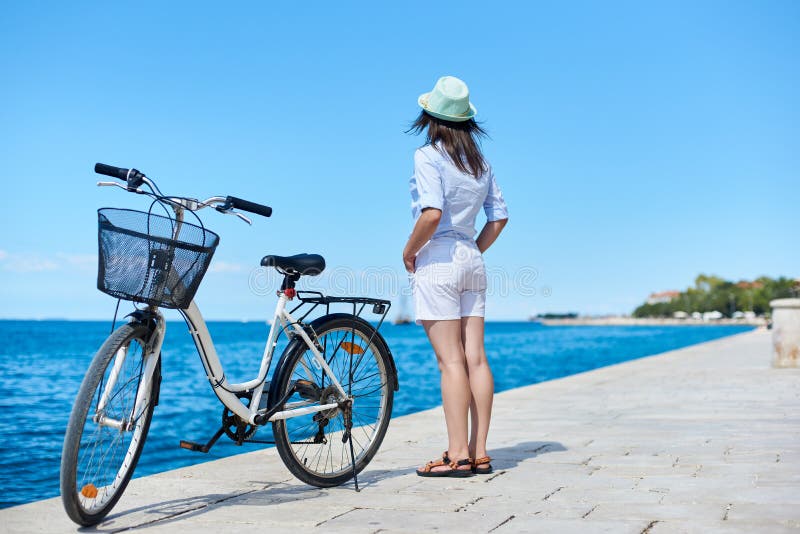 Bicyclette de ville d'?quitation de jeune femme pr?s de mer images stock Bicyclette de ville d'?quitation de jeune femme pr?s de mer images stock
