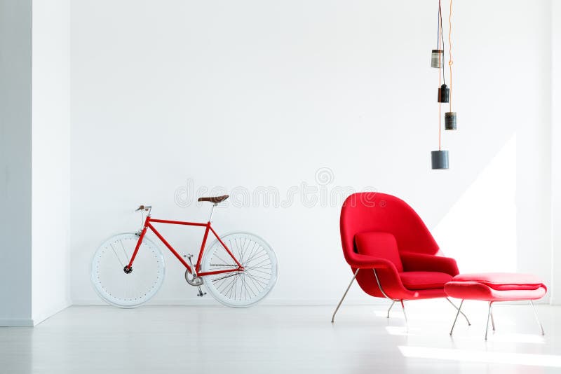 Bicyclette et fauteuil rouges sous la lampe en appartement minimal blanc i image stock Bicyclette et fauteuil rouges sous la lampe en appartement minimal blanc i image stock