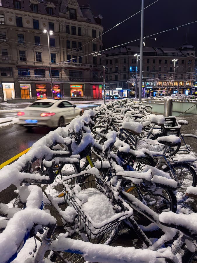 Zurich, Switzerland - December 2, 2023: Parke bicycles in the town of Zurich, covered with snow after a heavy snowfall in Zurich. Night shot. Zurich, Switzerland - December 2, 2023: Parke bicycles in the town of Zurich, covered with snow after a heavy snowfall in Zurich. Night shot