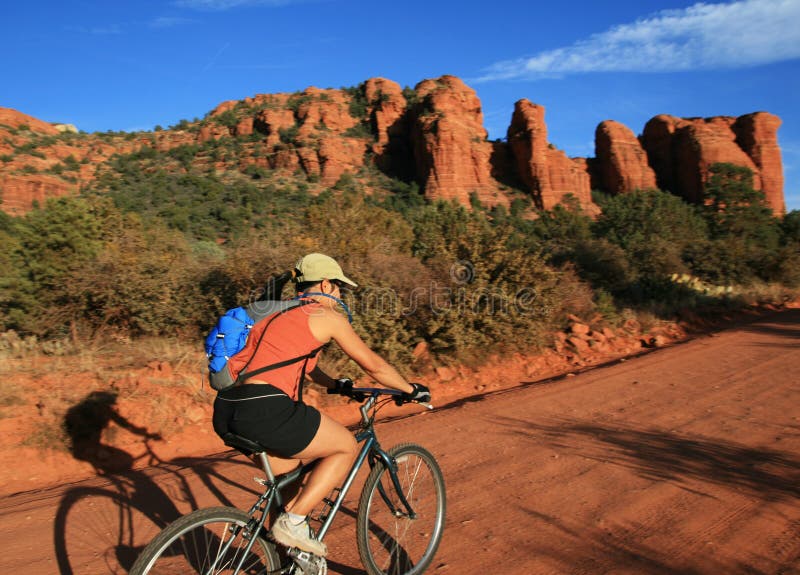 An Asian woman mountain biking along a dirt road near Sedona Arizona. An Asian woman mountain biking along a dirt road near Sedona Arizona