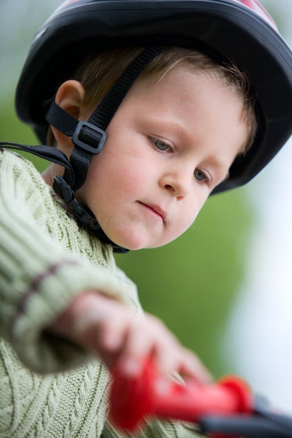 3 years old boy wearing safety bicycle helmet riding a bike. 3 years old boy wearing safety bicycle helmet riding a bike