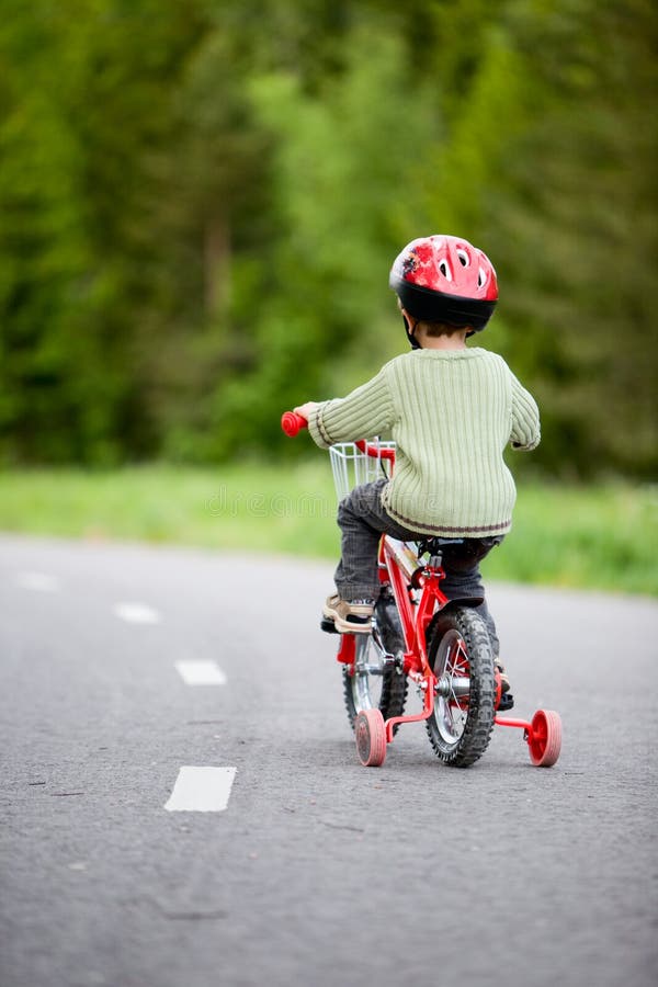 3 years old boy wearing safety bicycle helmet riding a bike. 3 years old boy wearing safety bicycle helmet riding a bike