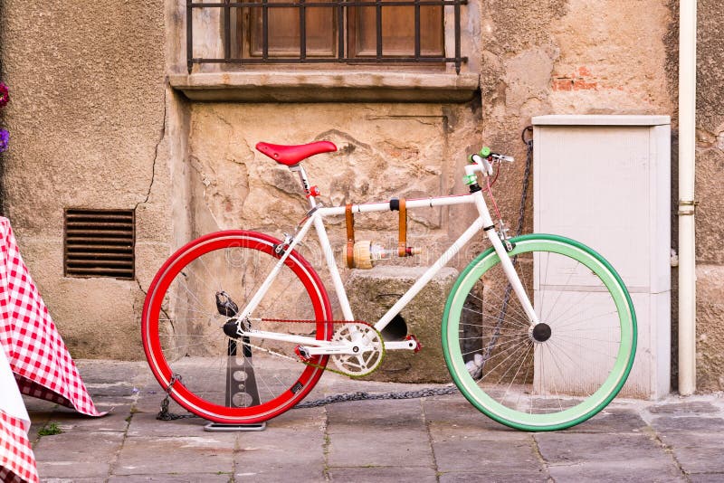 Bicykl z kolorami włoszczyzny flaga obok ściany wewnątrz zdjęcia stock Bicykl z kolorami włoszczyzny flaga obok ściany wewnątrz zdjęcia stock