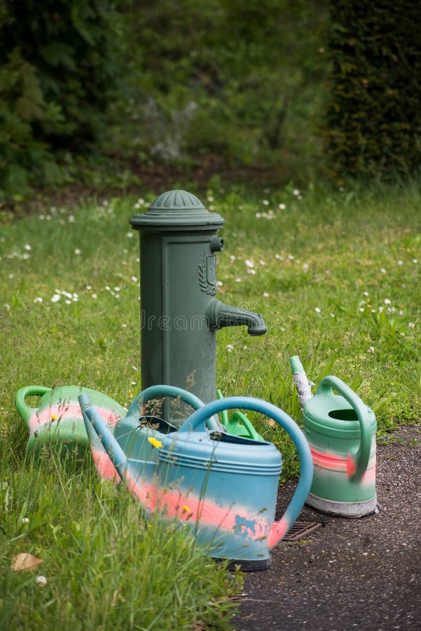 Bidons D'eau En Plastique Près D'une Fontaine Vintage Dans Un