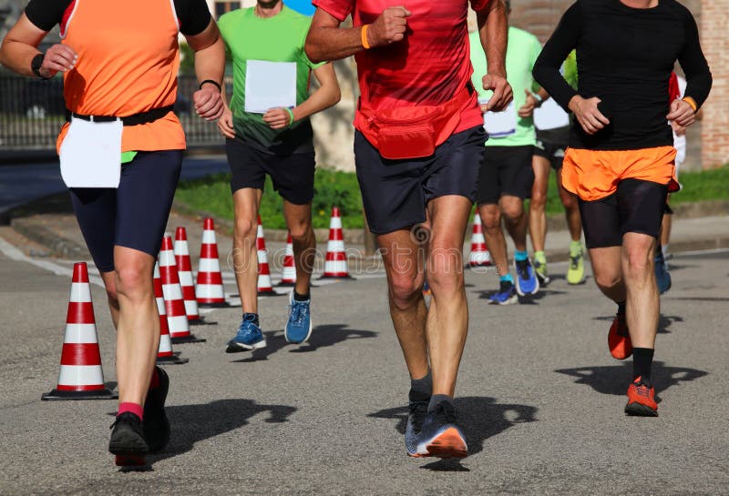 Biegacze podczas maratonu na ulicach miasta biegają w trampolinach. Wielu biegaczy podczas maratonu na ulicach miasta biegnie w trampolinach
