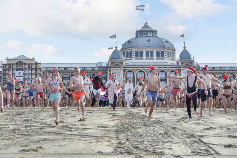 SCHEVENINGEN, 1 January 2018 - Dutch people following the strong tradition of the first new year dive run toward the frozen North Sea water after the midday ring bells on The Hague beach. SCHEVENINGEN, 1 January 2018 - Dutch people following the strong tradition of the first new year dive run toward the frozen North Sea water after the midday ring bells on The Hague beach