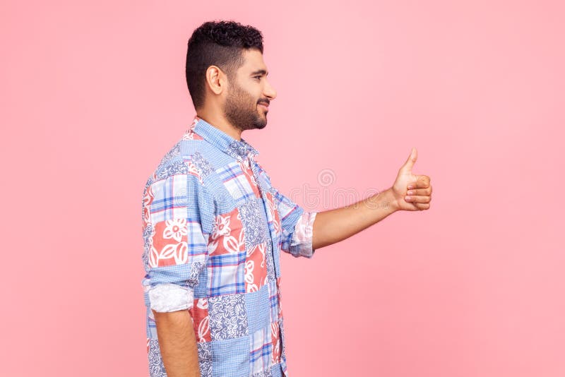 Bien fait! vue latérale de beau homme souriant heureux avec barbe vêtu de chemise bleu style décontracté en regardant vers l'aveni photographie stock