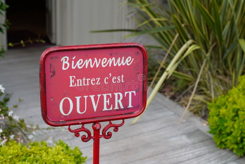 Circular blue sign in the window of a shop saying in French Magasin ouvert  à tous, meaning in english Store open to all Stock Photo - Alamy