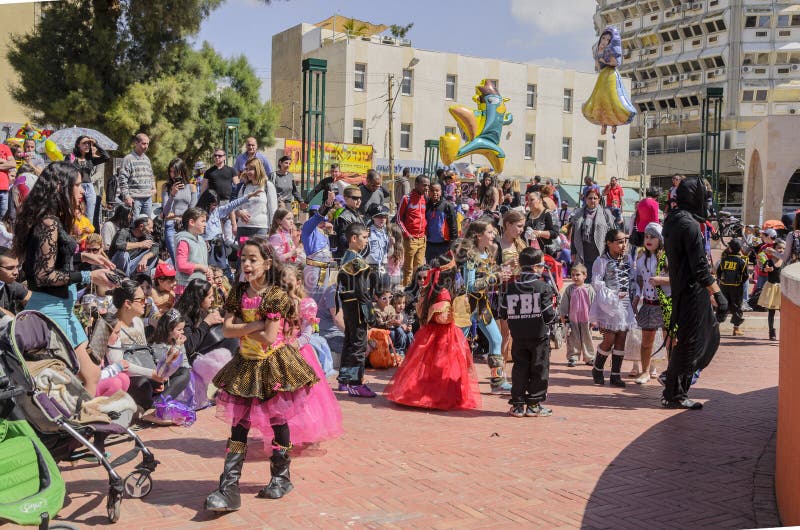 Bier-Sheva, ISRAËL - Maart 5, 2015: Kinderen in Carnaval-kostuums met hun ouders op de straat in viering van Purim royalty-vrije stock foto Bier-Sheva, ISRAËL - Maart 5, 2015: Kinderen in Carnaval-kostuums met hun ouders op de straat in viering van Purim royalty-vrije stock foto