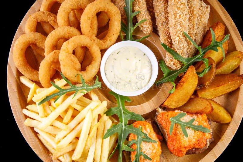 Bierplatte briet Rippenzwiebelringpommes-frites z. B. in bildgebender Diagnostik, auf einer hölzernen Panel auf einem schwarzen bac. in bildgebender Diagnostik, auf einer hölzernen Panel auf einem schwarzen Hintergrund zu fischen.