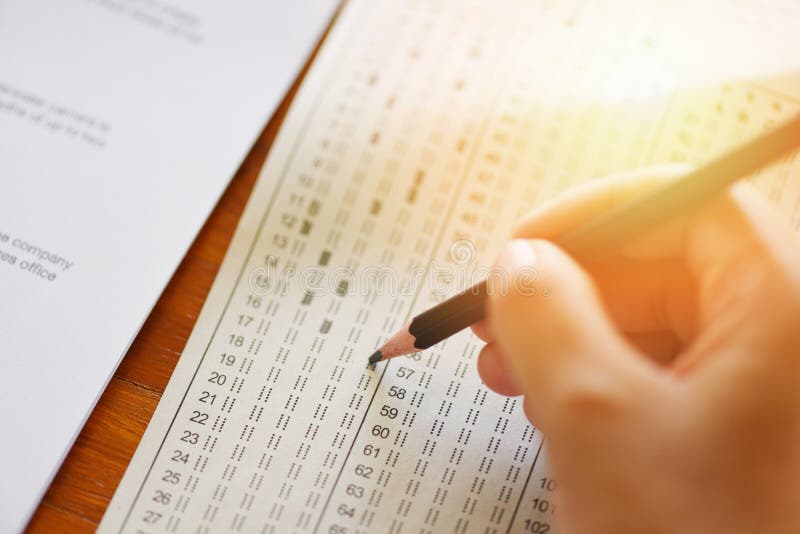 Bierze egzaminowi definitywną szkoły średniej rękę studencki mienie ołówek pisze na papierowym odpowiedzi prześcieradle - edukacj obrazy royalty free Bierze egzaminowi definitywną szkoły średniej rękę studencki mienie ołówek pisze na papierowym odpowiedzi prześcieradle - edukacj obrazy royalty free