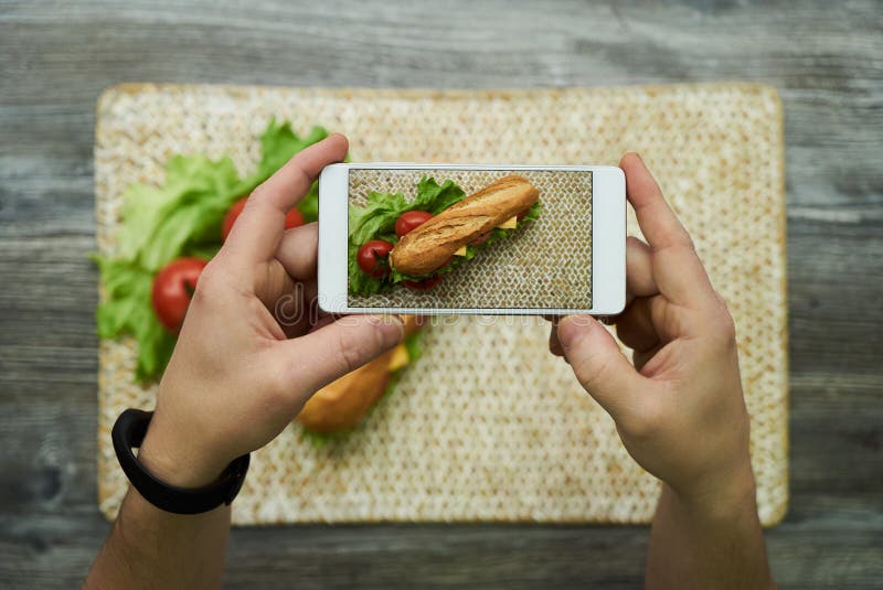 Bierze fotografię na telefonie komórkowym długa kanapka zdjęcie royalty free Bierze fotografię na telefonie komórkowym długa kanapka zdjęcie royalty free