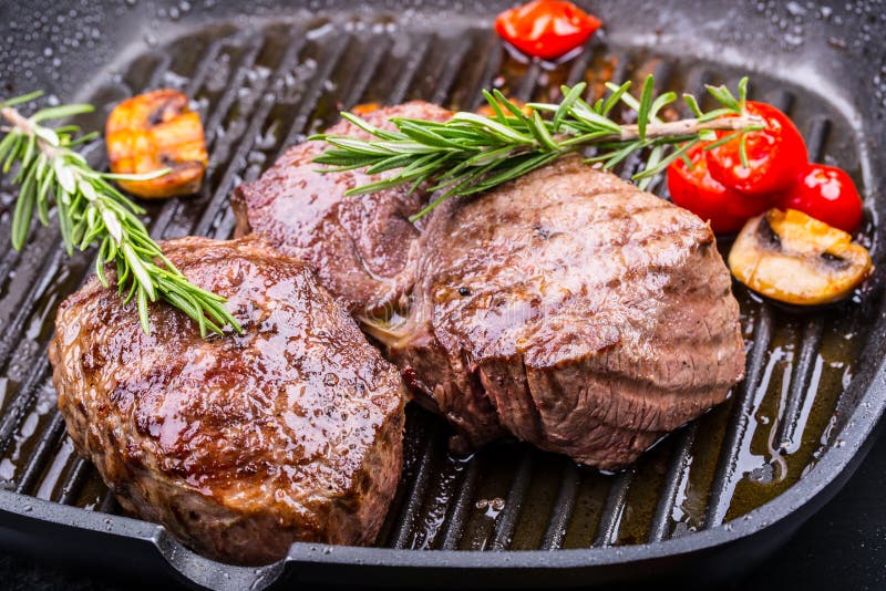 Grill beef steak. Portions thick beef juicy sirloin steaks on grill teflon pan or old wooden board. Grill beef steak. Portions thick beef juicy sirloin steaks on grill teflon pan or old wooden board.