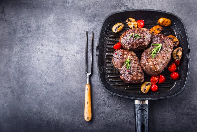 Grill beef steak. Portions thick beef juicy sirloin steaks on grill teflon pan or old wooden board. Grill beef steak. Portions thick beef juicy sirloin steaks on grill teflon pan or old wooden board.