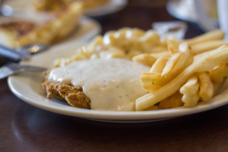 Bife à milanesa de frango e batatas fritas imagens de stock
