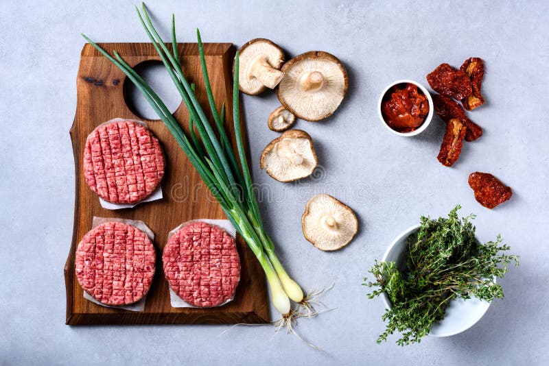 Bife triturado marmoreado fresco cru da carne, temperos no backgroun cinzento foto de stock Bife triturado marmoreado fresco cru da carne, temperos no backgroun cinzento foto de stock