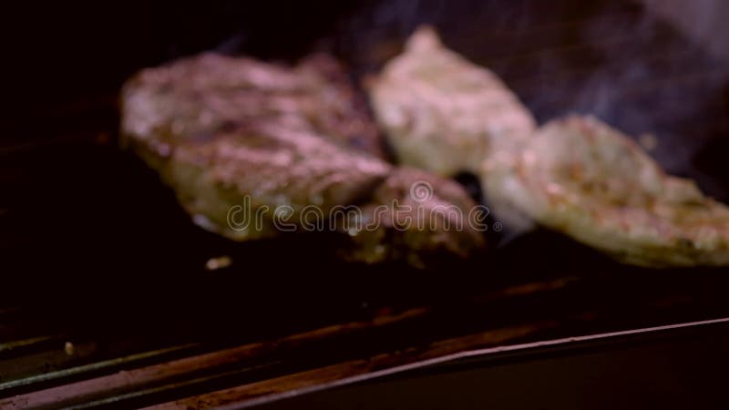 Bifes de carne sobre a grelha com vista de aproximação à chama