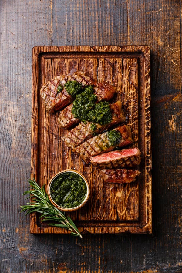 Bifteck d'aloyau coupé en tranches de boeuf avec de la sauce à chimichurri photos libres de droits Bifteck d'aloyau coupé en tranches de boeuf avec de la sauce à chimichurri photos libres de droits