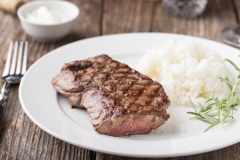 Bifteck de boeuf grillé avec du riz et le romarin image libre de droits Bifteck de boeuf grillé avec du riz et le romarin image libre de droits