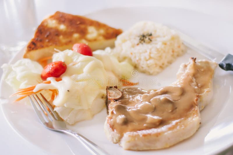 Bifteck grillé de côtelette de porc avec la sauce aux champignons photographie stock libre de droits Bifteck grillé de côtelette de porc avec la sauce aux champignons photographie stock libre de droits