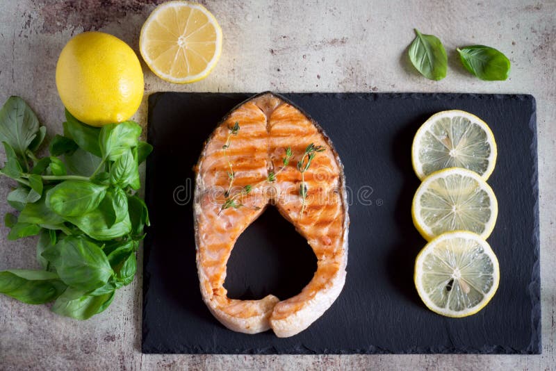 Bifteck saumoné délicieux avec les tranches minces de citron d'un plat image libre de droits Bifteck saumoné délicieux avec les tranches minces de citron d'un plat image libre de droits