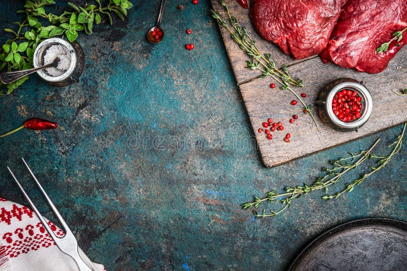 Biftecks de viande crue avec les assaisonnements frais sur le fond en bois rustique, vue supérieure images libres de droits Biftecks de viande crue avec les assaisonnements frais sur le fond en bois rustique, vue supérieure images libres de droits