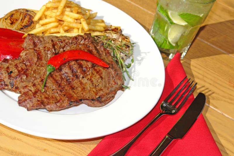 Big beef Steak with garnish and mojito stock images