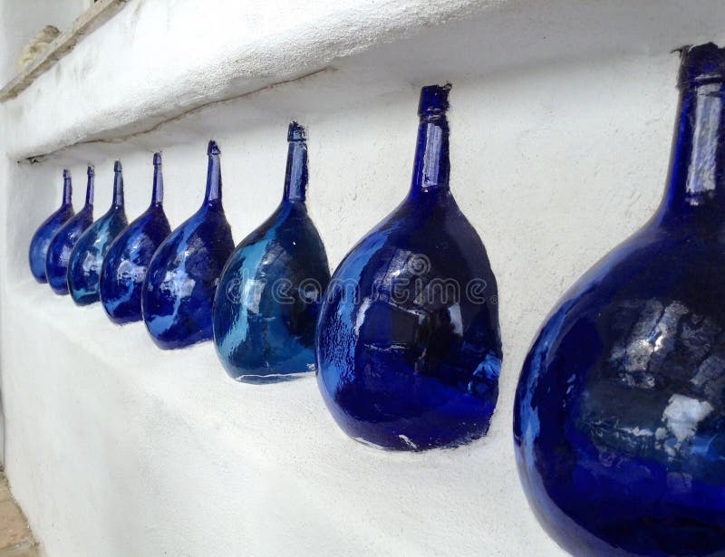 Big Blue Wine Bottles Cemented in Wall of White Stucco Spanish House