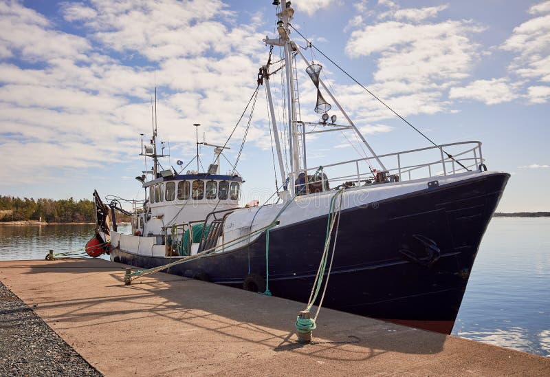 Big fishing ship anchored on the dock on a sunny summer day stock photos Big fishing ship anchored on the dock on a sunny summer day stock photos