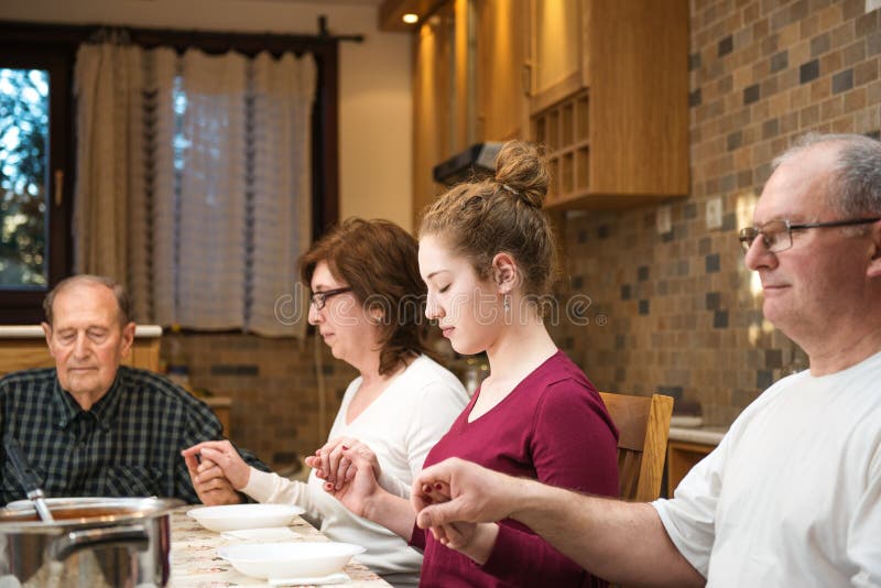 Big generation family praying at dinner stock photos Big generation family praying at dinner stock photos