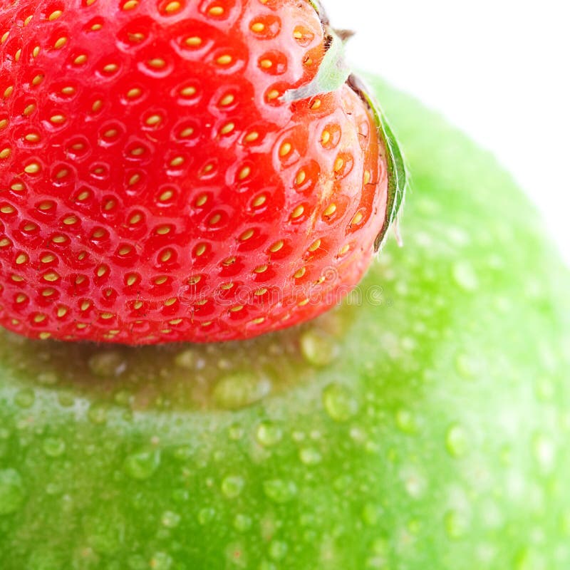 Big green apple with water drops and strawberries