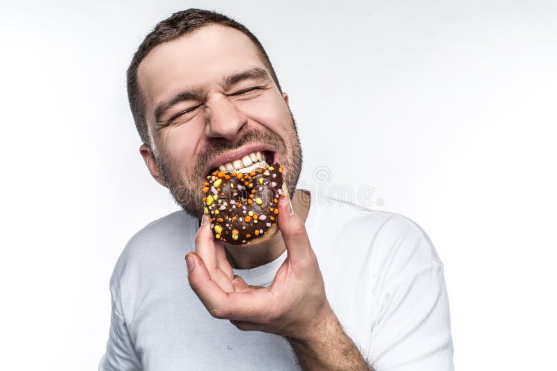 Big guy is starving. He decided to eat tasty small fat donut covered with chocolate. He is biting it with delisions