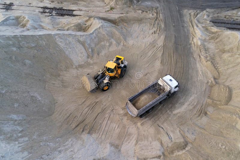 Big Heavy Wheel Loader Loading Sand into Dump Truck in Sand Pit. Heavy